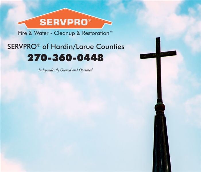 Photo of cloudy sky with a cross on the right side of photo. Orange SERVPRO logo with phone number in upper left corner